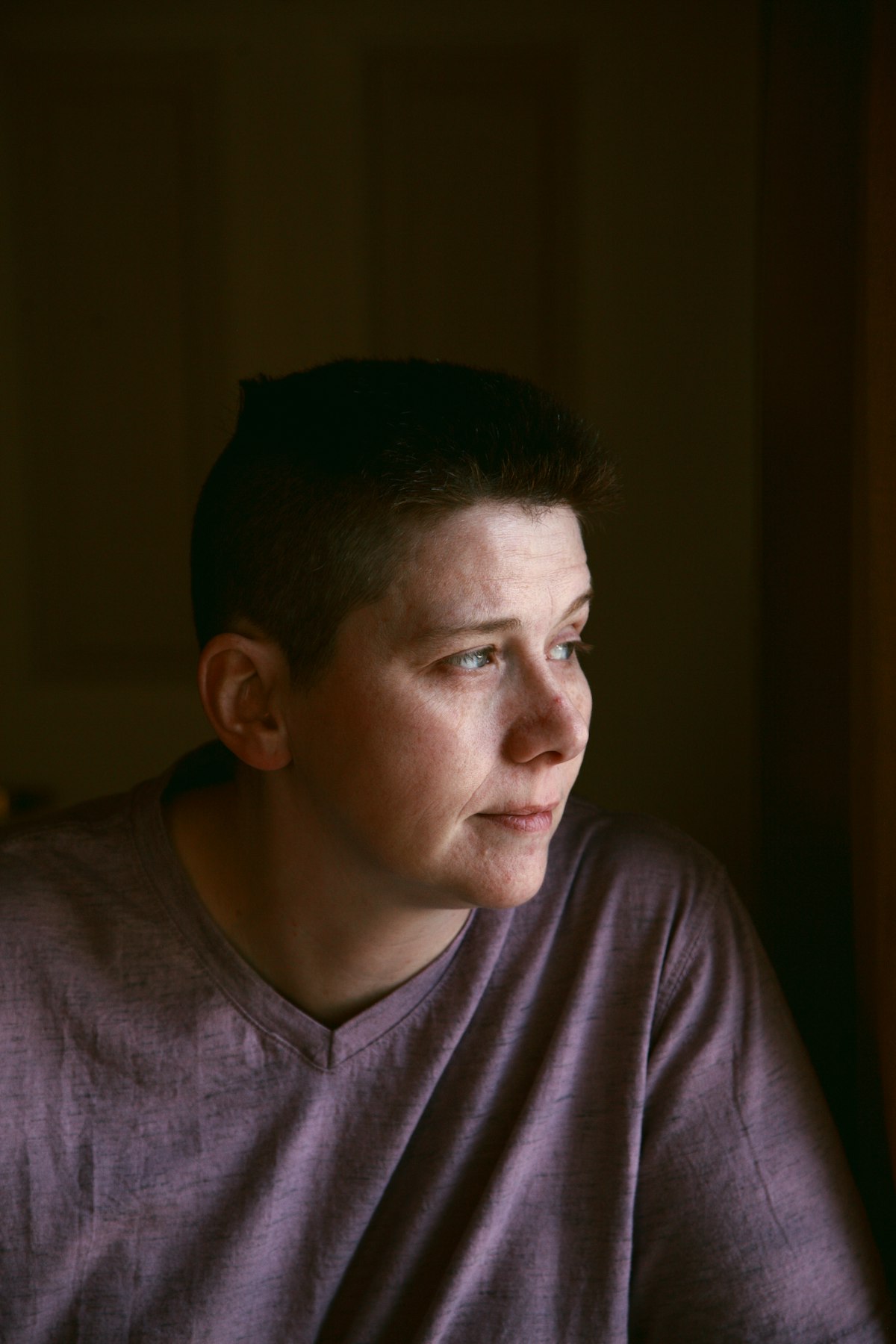 A person looking out of a window, deep in thought